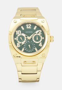 Orologio in acciaio inossidabile placcato oro con quadrante verde, grandi numeri bianchi, più sottodial e design del bracciale a maglie.