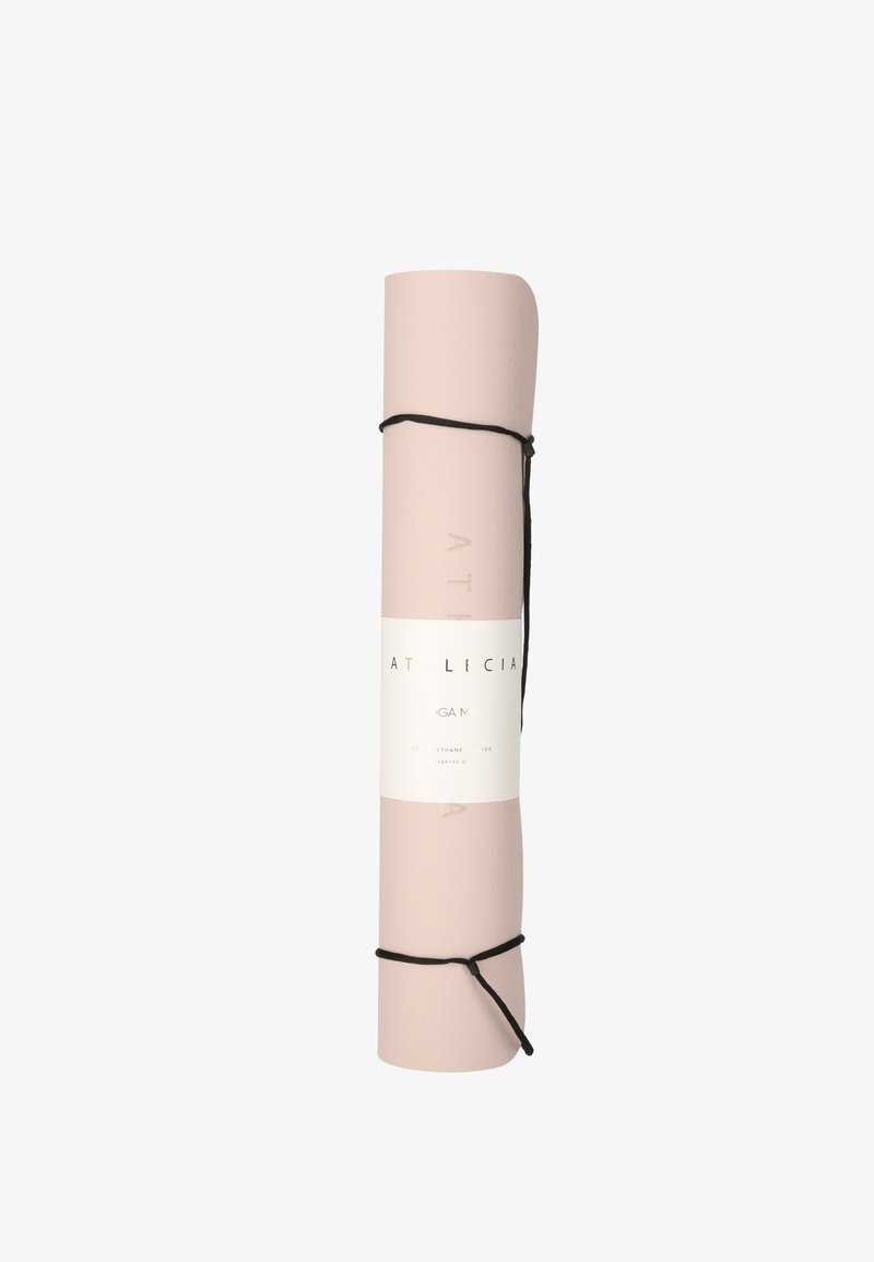 Tapis de yoga rose clair roulé, maintenu par des sangles noires, étiqueté "Athlecia", sur fond blanc.