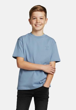 Lichtblauw katoenen T-shirt met een ronde hals en korte mouwen, met een subtiel logo op de borst. Gecombineerd met zwarte jeans.