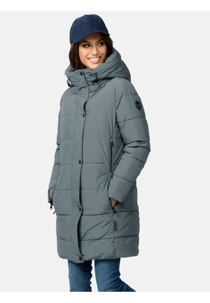 Manteau rembourré gris avec une capuche, des boutons-pression et deux poches latérales. Texture matelassée et un patch rond avec un logo sur la manche gauche. Casquette marine portée.