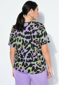 T-shirt met korte mouwen en een multicolor luipaardprint in zwart, paars en groen; gemaakt van zachte stof met een losse pasvorm.