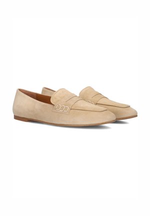 Beige suède instappers met een zachte textuur, een verlengde vorm en gestikte details op de bovenkant. Platte zolen voor comfortabel dragen.