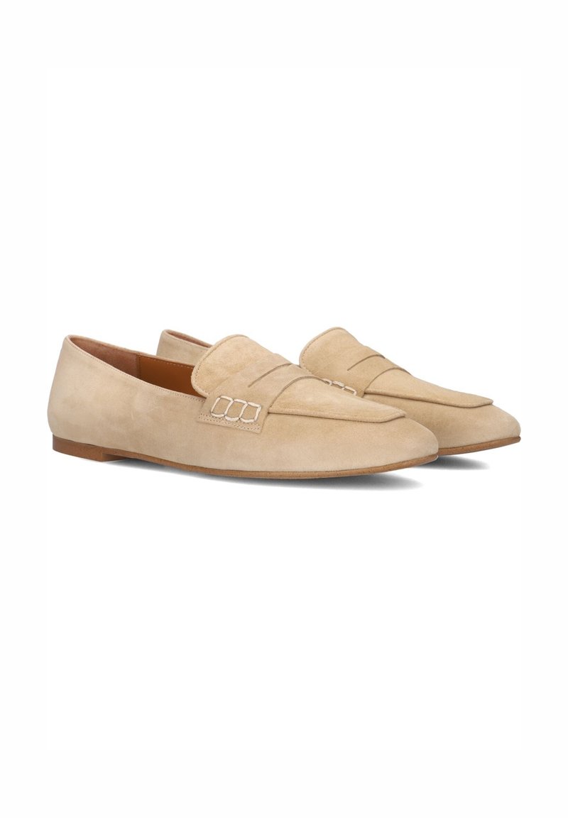 Beige suède instappers met een zachte textuur, een verlengde vorm en gestikte details op de bovenkant. Platte zolen voor comfortabel dragen.