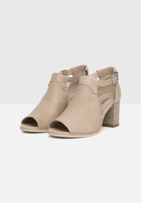 Scarpe alla caviglia aperte color beige con tomaia in tessuto strutturato, dotate di cinturino con fibbia e tacco a blocco. Fodera interna liscia.