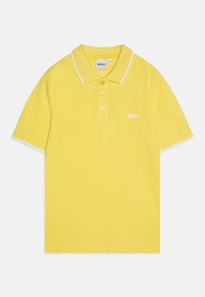 Polo jaune à manches courtes avec bordure blanche sur le col et les manches, trois boutons, et logo "BOSS" brodé sur la poitrine.