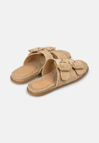 Sandali a fascia in tessuto beige intrecciato con due grandi fiocchi sulla parte superiore. Suola interna con texture naturale e suola in gomma.