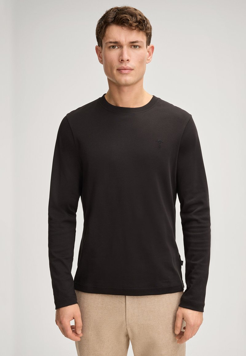 Langärmliges schwarzes T-Shirt aus leichtem Stoff. Hat einen runden Ausschnitt und ein kleines Logo auf der Brust. Einfaches, tailliertes Design.