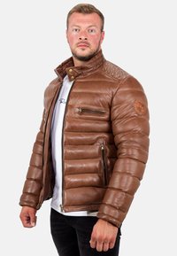 Giubbotto puffo in pelle marrone con colletto alto, design a trapunta orizzontale, due tasche laterali con zip e una tasca sul petto con zip.