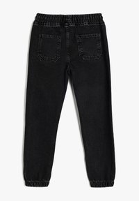 Joggers de mezclilla negra con una cintura elástica, dos bolsillos traseros y puños elásticos en los tobillos. Textura suave con un ligero brillo.