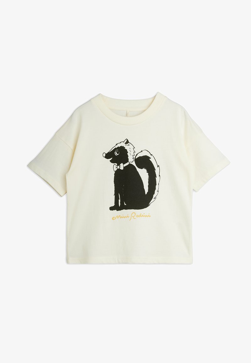 T-shirt crème à manches courtes avec un putois dessin animé noir et blanc portant un nœud papillon imprimé sur le devant.