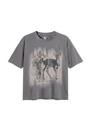 Szary t-shirt z krótkim rękawem z czarno-białą ilustracją jelenia i skomplikowanymi kwiatowymi wzorami, zawierający tekst "Mystic Meadow."