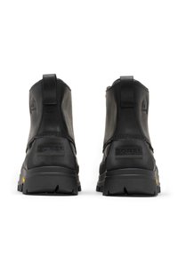 Svarta läderstövlar till ankeln med texturerad yta, utrustade med en dragflik, robust gummisula och präglad varumärkeslogotyp på baksidan.