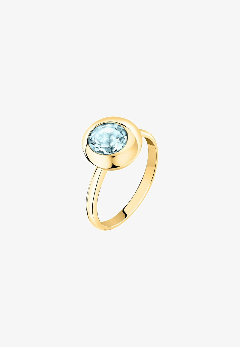 Anello in oro con una fascia liscia e una pietra preziosa rotonda di un blu chiaro, tagliata a faccette e incastonata in una bezza circolare. Finitura lucida senza ulteriori decorazioni.