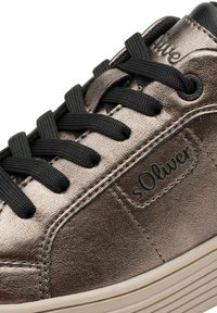 Sneaker in bronzo metallico con lacci neri, caratterizzato da dettagli cuciti e una superficie testurizzata. Il nome del marchio "sOliver" è impresso sul lato.