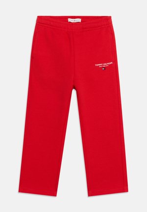 Pantalon de survêtement rouge avec poches latérales et taille élastique, avec texte blanc "Tommy Hilfiger New York City" et petit logo sur la jambe droite avant.