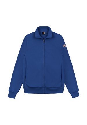 Chaqueta azul con cremallera, cuello alto, puños y dobladillo acanalados, y parche redondo con logo en la manga izquierda.