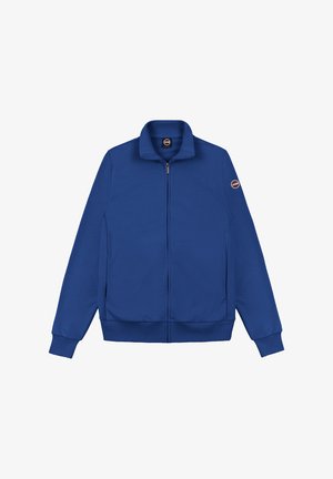 Blauwe jas met ritssluiting, opstaande kraag, geribde boorden aan mouwen en zoom, en een ronde logopatch op de linker mouw.