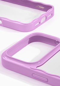 Fioletowe plastikowe etui na telefon z falistym wzorem, przezroczystym tyłem, wycięciami na przyciski i błyszczącym wykończeniem. Idealne do ochrony i stylu.