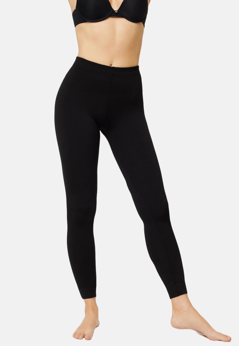 Leggings negros de tela elástica, con una cintura alta y un ajuste ceñido, sin patrones ni acentos visibles.