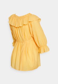 Blusa amarela com um decote em ruffles e mangas balão, apresentando um tecido texturizado e uma cintura com cinto para definir a silhueta.
