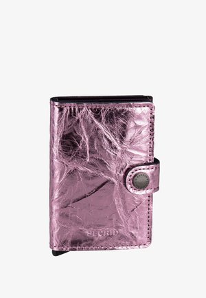 Cartera compacta de cuero metálico rosa con cierre de botón a presión y costuras visibles, texturizada con arrugas naturales y nombre de la marca en relieve.