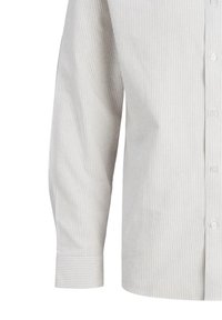 Camisa de botón de manga larga en rayas grises y blancas. Presenta un cuello tipo polo, material de algodón suave y un detalle de puño con un solo botón.
