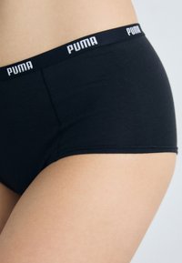 Slip in cotone nero con ampia cintura elastica con il marchio "PUMA" in bianco. Texture liscia, design classico e forma aderente.