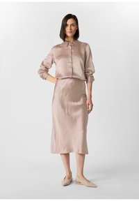 Seidene, hellrosa Bluse mit Kragen und durchgehender Knopfleiste, kombiniert mit einem passenden knielangen Rock. Schlichte, strukturierte Gestaltung.