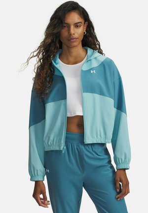 Chaqueta corta con cremallera en azul claro y verde azulado, con capucha, puños elásticos y logotipo de Under Armour en el pecho izquierdo.