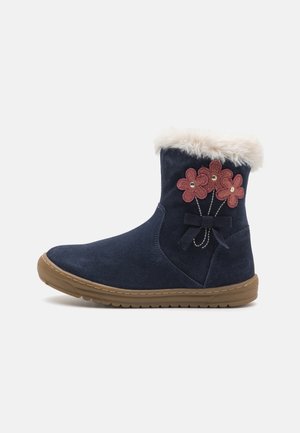 Bottes cheville en daim bleu marine avec bordure en fausse fourrure, motif de broderie florale avec des fleurs roses, et une semelle en caoutchouc marron.