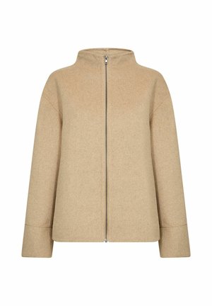 Veste en mélange de laine beige avec un col montant, une fermeture éclair sur le devant et des épaules tombantes. Le tissu a une finition douce et texturée.