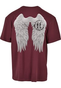 Tricou din bumbac de culoare vișinie, cu un grafic mare al aripilor de înger albe pe spate, și un logo circular negru în partea superioară, aproape de gât.