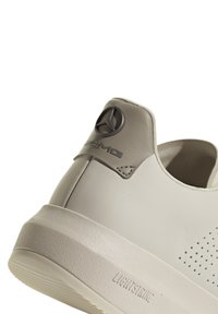 Grå lädersneaker med en texturerad yta, med en logotypaccent på hälen, minimalistisk design och en lätt sula.