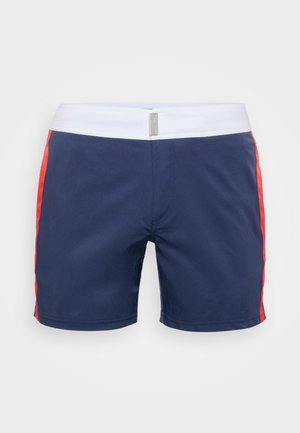 Pantalones de natación azul marino con franjas laterales rojas y una cinturilla elástica blanca. Fabricados con material ligero y costuras reforzadas.