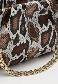 Bolso con estampado de piel de serpiente en tonos marrón, blanco y negro, con una cadena dorada. Presenta un логotipo en la parte frontal, resaltando la superficie texturizada.