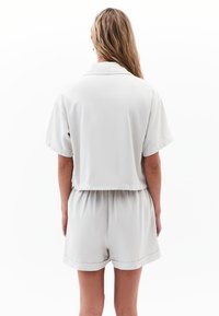 Jasnoszara, krótka koszula z kołnierzykiem z krótkim rękawem o skróconym kroju, w zestawie z dopasowanymi szortami z elastycznym pasem i mankietami.