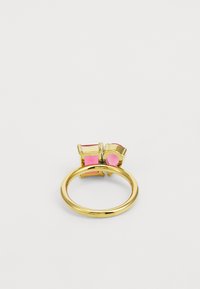 Gold-tone ring featuring a rounded band with three rectangular and circular pink enamel accents on one side. Smooth texture.
