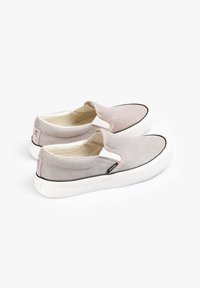Schlüpfschuhe aus hellgrauem Stoff mit weißer Gummisohle. Verfügt über elastische Einsätze, schwarze Besätze und ein dezentes Logo an der Ferse.