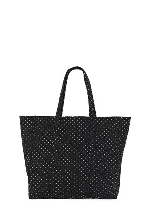 Sac cabas matelassé noir avec des pois blancs et deux anses, présenté debout sur un fond blanc.