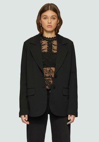 Schwarzer taillierter Blazer aus glattem Stoff, mit strukturiertem Design, Reverskragen, zwei Knöpfen und seitlichen Taschen.