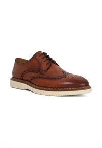 Brown leather lace-up shoe with perforated detailing, contrasting white sole, and a classic brogue design. Smooth texture and rounded toe.