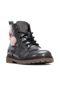 Botas de tobillo negras con purpurina, pompones rosas y detalles de estrellas. Presentan un material brillante, cordones negros y una suela marrón gruesa.