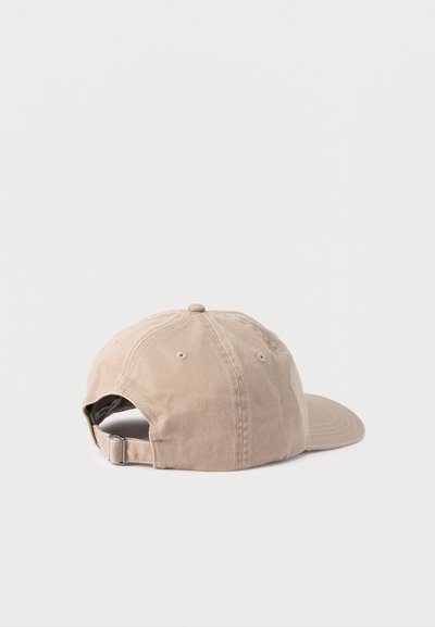 Μπεζ ρυθμιζόμενο καπέλο μπέιζμπολ από ύφασμα με κλείσιμο μεταλλικής πόρπης, εμφανιζόμενο από πίσω σε απλό φωτεινό φόντο.