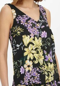Kwiatowy top na ramiączkach z czarnym tłem, na którym znajdują się żółte, fioletowe i białe kwiaty, w kształcie litery V oraz dekoracyjnym detalem z guzików.