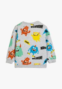 Sudadera gris con coloridos monstruos de dibujos animados en varias poses, acompañados de elementos textuales como "¡BLEEEH!" y "¡SÍ!" en una fuente audaz y divertida.