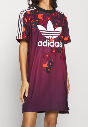 Vestido deportivo burdeos con estampado floral en rojo y negro. Presenta el logo blanco de Adidas y tres rayas en las mangas. Corto, de corte holgado.