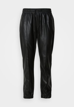 Schwarze Jogginghosen aus Kunstleder mit elastischem Bund, Kordelzug, Seitentaschen und elastischen Bündchen auf einem neutralen Hintergrund.