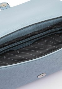Borsa a mano in pelle azzurro chiaro con superficie texturizzata, apertura con zip e interno foderato di nero con un sottile motivo diagonale.