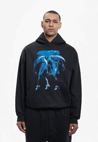 Sort hættejakke med et stort blåt grafisk design på forsiden, pullover stil med en frontlomme og en behagelig pasform.