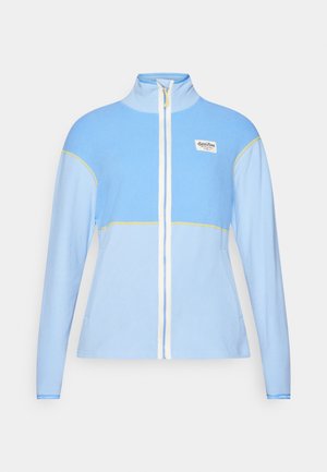 Lys blå fleecejakke med høy krage, hel glidelås, hvite detaljer og gule sting. Har en liten logo på øvre venstre side.